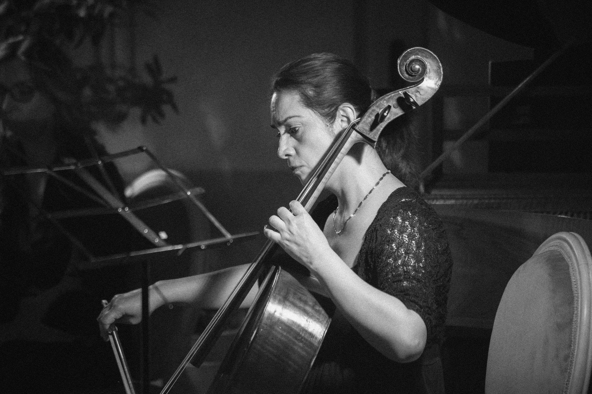 A cellist playing in close-up, eyes lowered to the strings.