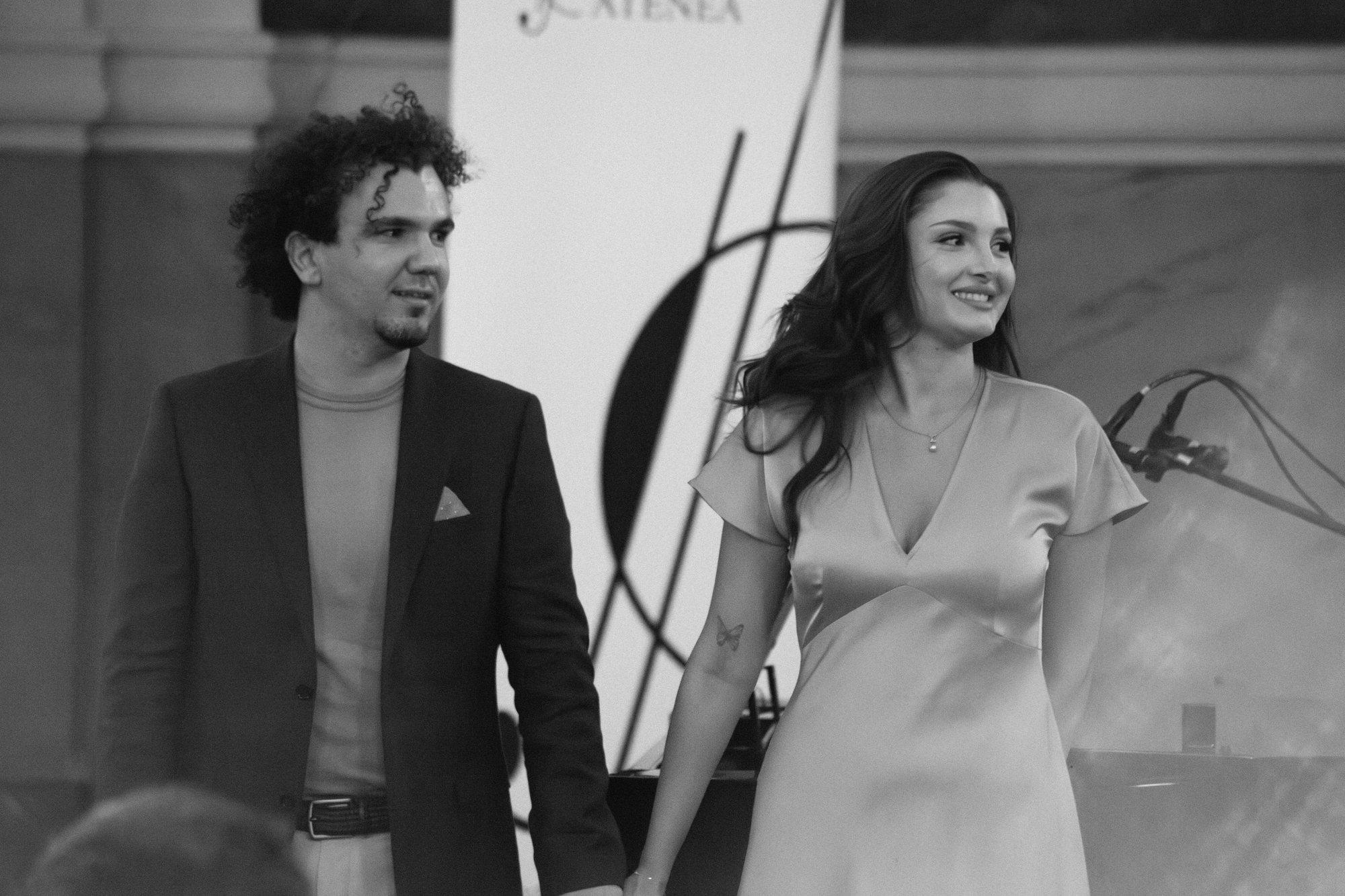 Deux interprètes, au chant et au piano, reçoivent les applaudissements en souriant.